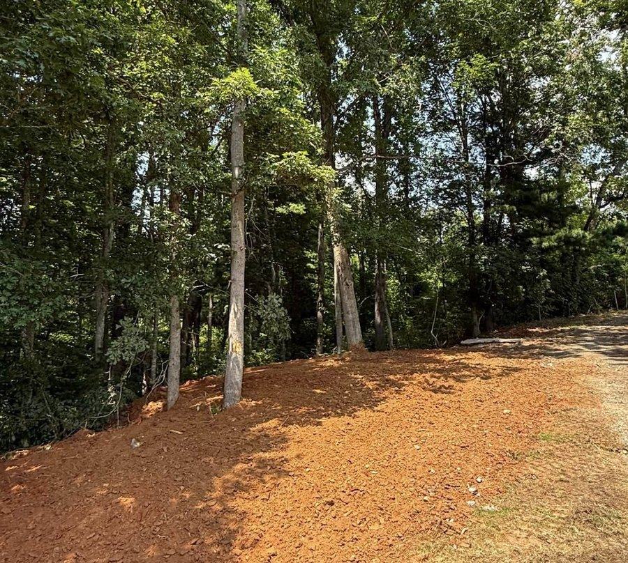 A cleared building lot showing exposed red clay after site preparation.