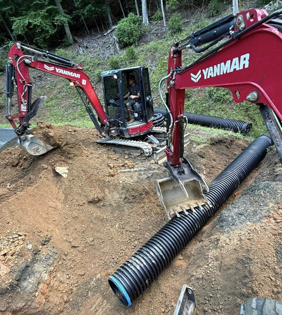 Culvert pipe being installed under a driveway crossing.
