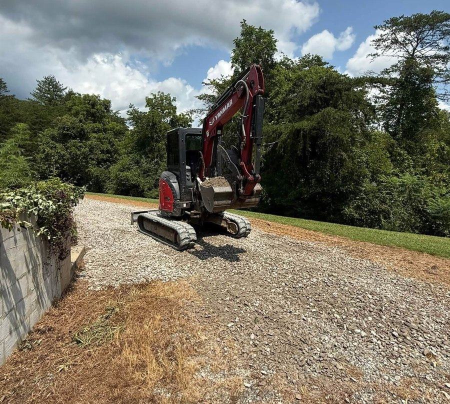 An excavator on a freshly cut driveway grade.