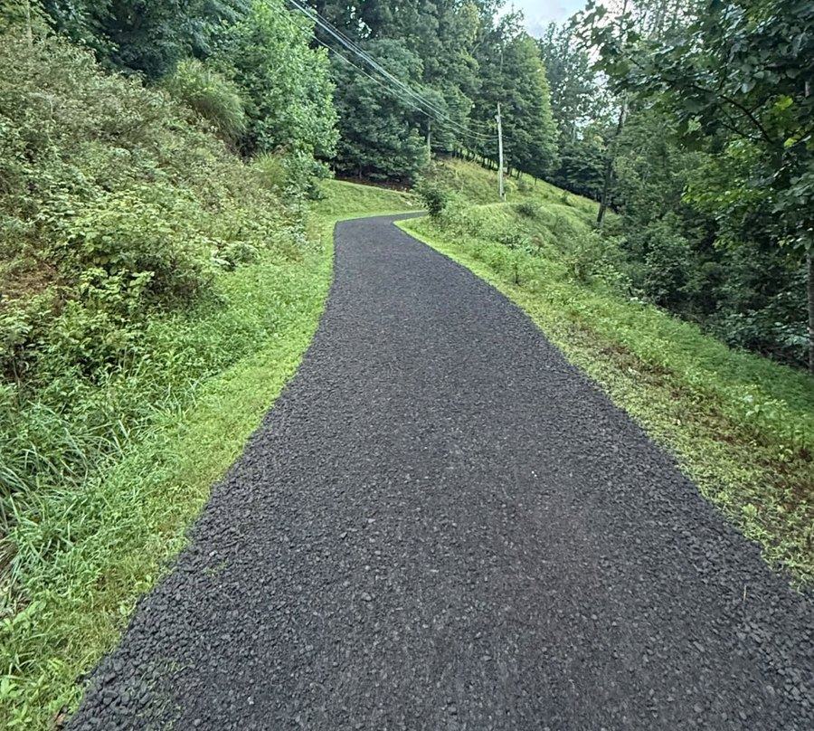 A finished driveway running through open pasture.